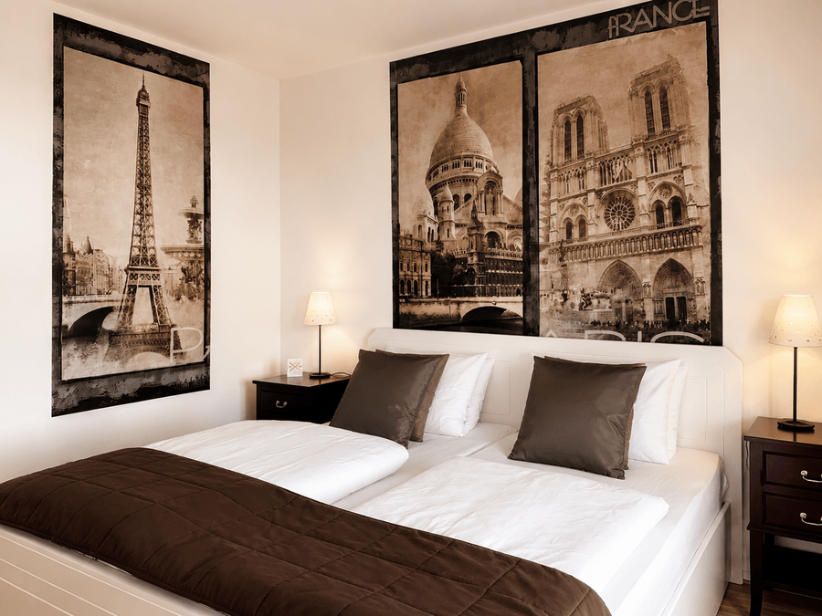 Helles Zimmer im Elbhotel mit komfortablem Bett und eleganten Wandmotiven